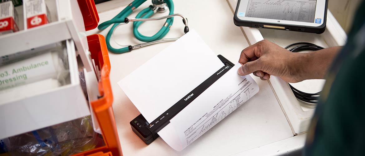 Une imprimante thermique de la gamme PJ de Brother imprime un document médical et jouxte trois véhicules d'urgence.