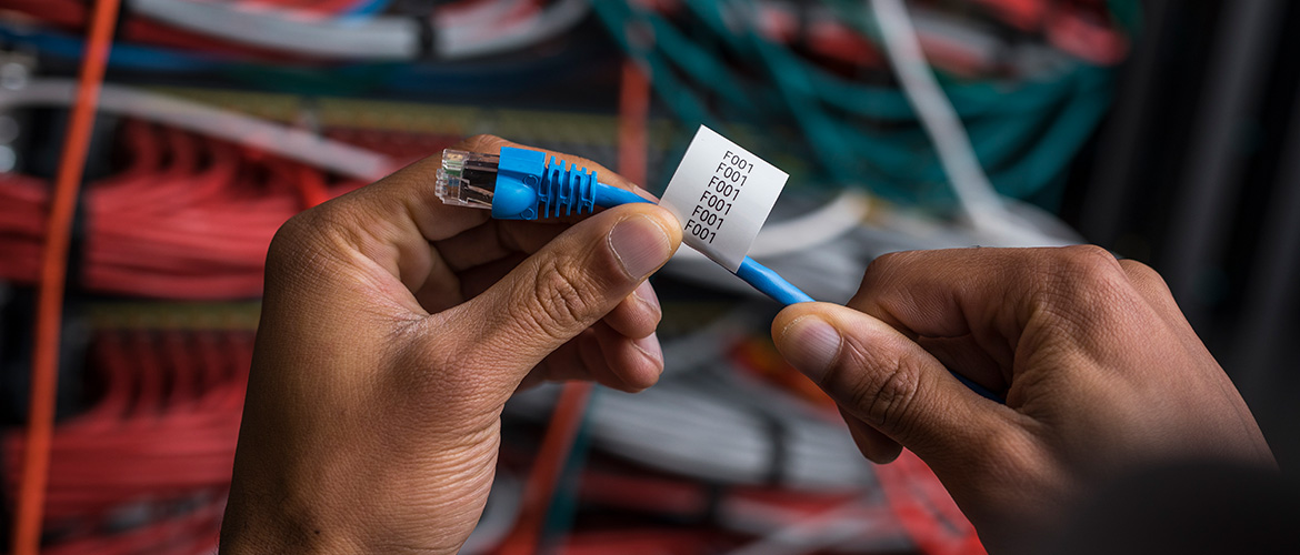 Un électricien manipule des câbles.