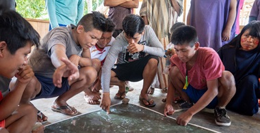 Groupe de personnes accroupies regardant une carte